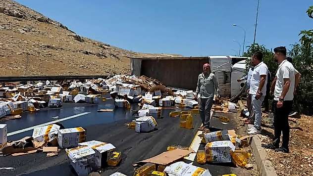 Devrilen tırdaki yağ bidonları yola savruldu