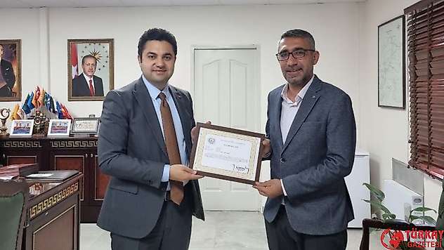 Kaymakam Seyhan Gençlik Spor ilçe müdürü Güleç'i başarı belgesiyle uğurladı