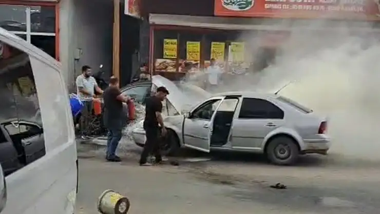 Adana'da yanan otomobili esnaf su ve yangın tüpüyle söndürdü